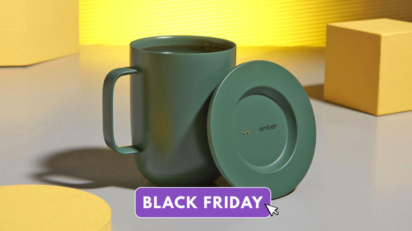 Product marketing photo of the Ember Smart Mug 2 in green. It sits on a whimsical table with a gray surface with several yellow blocks and geometrical shapes sitting aside it.