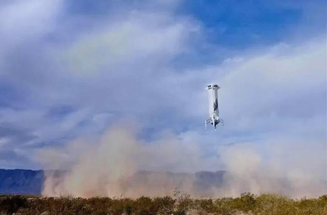 An image of a the Blue Origin New Shepard booster rocket lowering to Earth.  