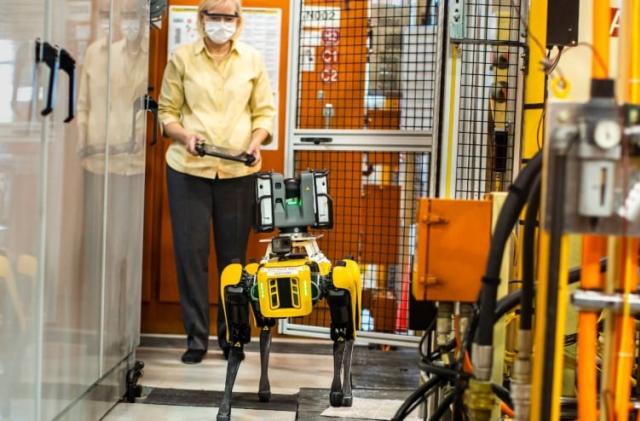 Paula Wiebelhaus, Fluffy’s handler, navigates Fluffy, the dog-like robot through tough-to-reach areas within the plant. Ford is tapping four-legged robots at its Van Dyke Transmission Plant in early August to laser scan the plant, helping engineers update the original computer-aided design.