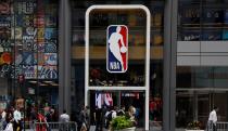 FILE PHOTO: The NBA logo is displayed as people pass by the NBA Store in New York City, U.S., October 7, 2019. REUTERS/Brendan McDermid/File Photo