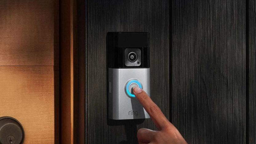 A hand pressing on a doorbell camera. 