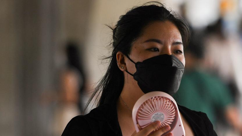 A woman uses a hand fan as temperatures hit a record 45.4 degrees Celsius (113.7 Fahrenheit) in Bangkok, Thailand, April 22, 2023. REUTERS/Chalinee Thirasupa