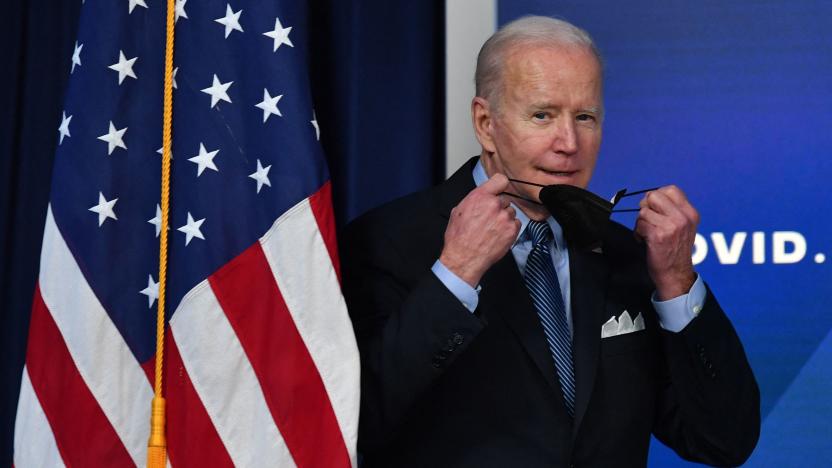 US President Joe Biden removes his protective mask while arrving to deliver remarks on Covid-19 in the South Court Auditorium, next to the White House, in Washington, DC, on March 30, 2022. (Photo by Nicholas Kamm / AFP) (Photo by NICHOLAS KAMM/AFP via Getty Images)