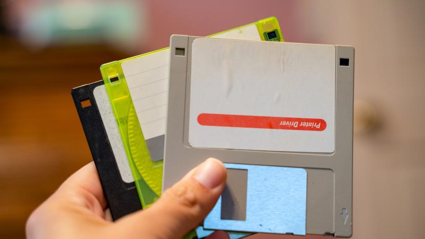 Hand holds out Three outdated 3.5 inch floppy disks, from the 1990s