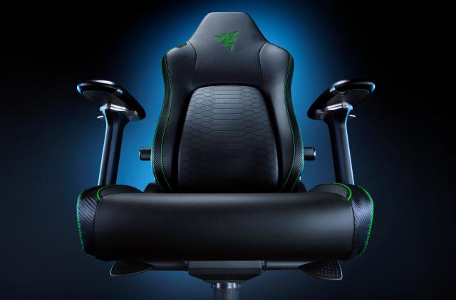 Product marketing photo of the Razer Iskur V2 Gaming Chair. Taken from a lower angle (just above the seat area), the dramatic shot has a blue glow fading to black behind the chair.
