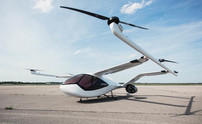 The Volocopter VoloConnect drone taxi sitting on a concrete runway with blue sky in the background.