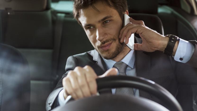 Close up of a handsome young businessman talking on mobile phone in his car