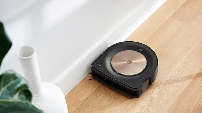 An iRobot Roomba s9+ is pictured cleaning a floor