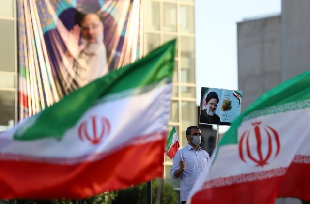 A supporter of presidential candidate Ebrahim Raisi holds a poster of him during an election rally in Tehran, Iran June 14, 2021. Majid Asgaripour/WANA (West Asia News Agency) via REUTERS ATTENTION EDITORS - THIS IMAGE HAS BEEN SUPPLIED BY A THIRD PARTY. ATTENTION EDITORS - THIS PICTURE WAS PROVIDED BY A THIRD PARTY