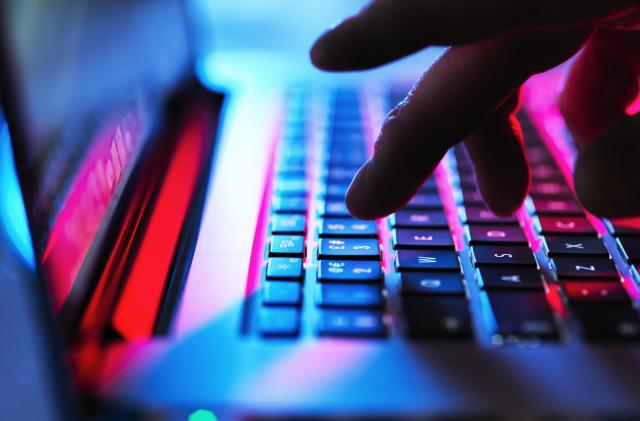 Man typing at his laptop computer at night