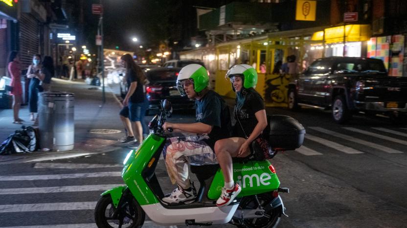 NEW YORK, NEW YORK - MAY 22: People without masks drive around on a Lime E-moped in the Lower East Side on May 22, 2021 in New York City. This is the first Saturday night that New York City is not under pandemic restrictions in more than a year. On May 19, all pandemic restrictions, including mask mandates, social distancing guidelines, venue capacities and restaurant curfews were lifted by New York Governor Andrew Cuomo. (Photo by Alexi Rosenfeld/Getty Images)