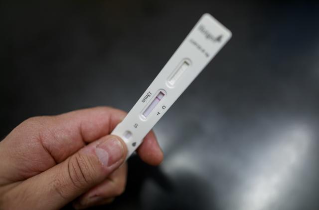 A hand holding a negative Covid-19 rapid test. The red line marking C. (Photo illustration by Achille Abboud/NurPhoto via Getty Images)