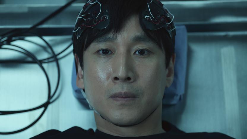 A still from Apple TV+ series Dr. Brain in which Sewon (Lee Sun-kyun) lies on a table wearing a headpiece covered in wires.