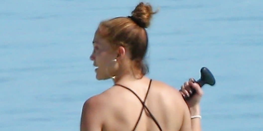 Jennifer Lopez enters the water in an elegant black swimsuit with straps