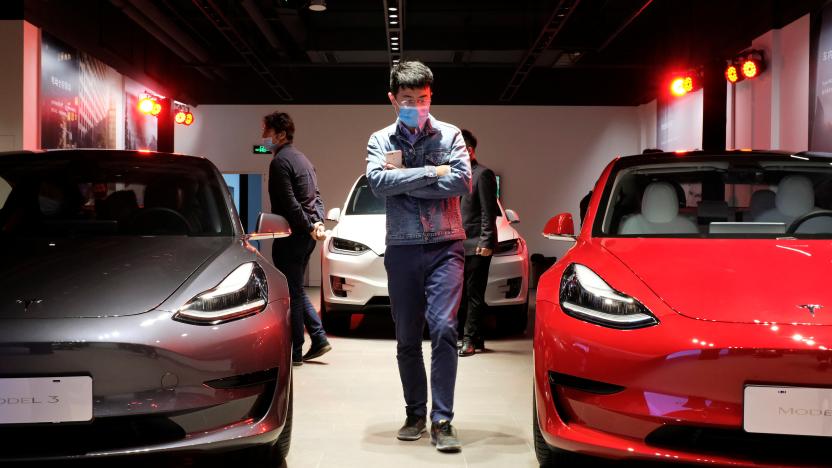 A man wearing a face mask following the coronavirus disease (COVID-19) outbreak walks by Tesla Model 3 sedans and Tesla Model X sport utility vehicle at a new Tesla showroom in Shanghai, China May 8, 2020. Picture taken May 8, 2020. REUTERS/Yilei Sun