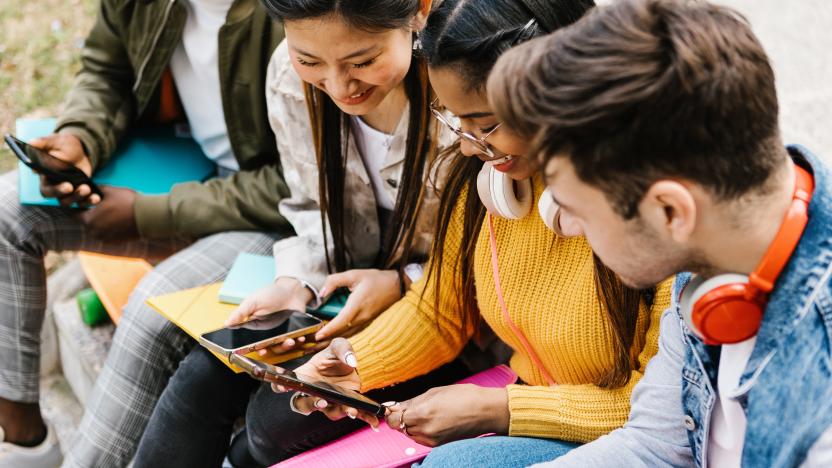 Diverse young teenage students having fun using mobile phone in college campus - Education, millennial people and social media concept