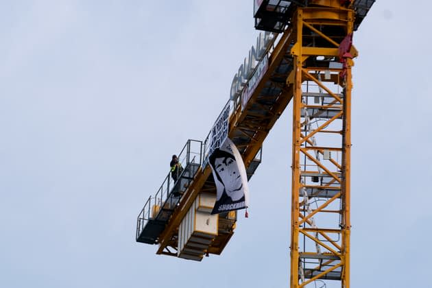 From the top of a crane, the father of a victim calls out Biden on the guns