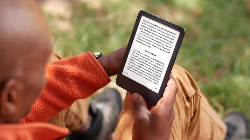 A bald man reading a Kindle.