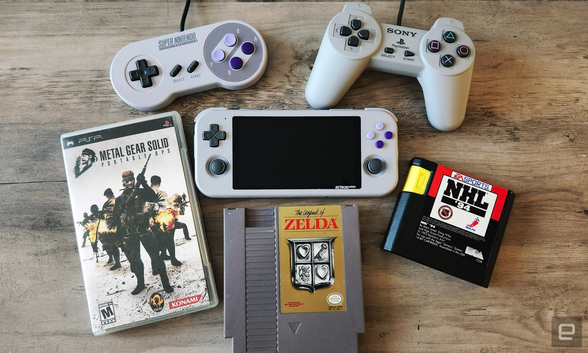 The Retroid Pocket 3 gaming handheld surrounded by old gaming cartridges and wired controllers.