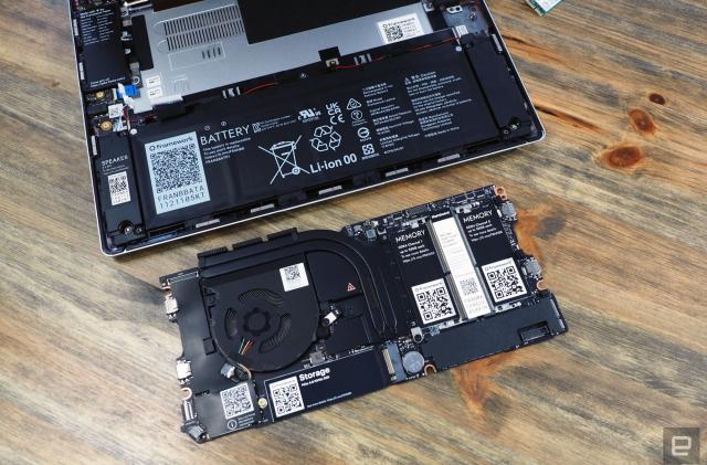 The Framework repairable laptop sitting with its exterior shell off and a replacement drive in front of it.
