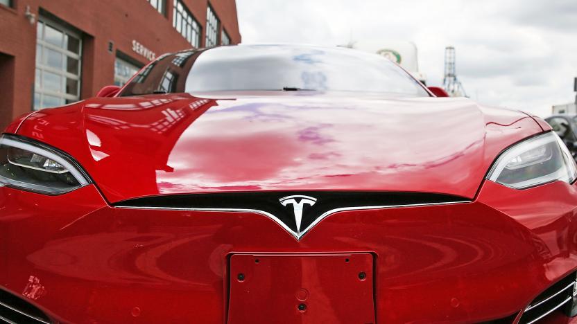 A closeup of a red Tesla's front grill / bumper.