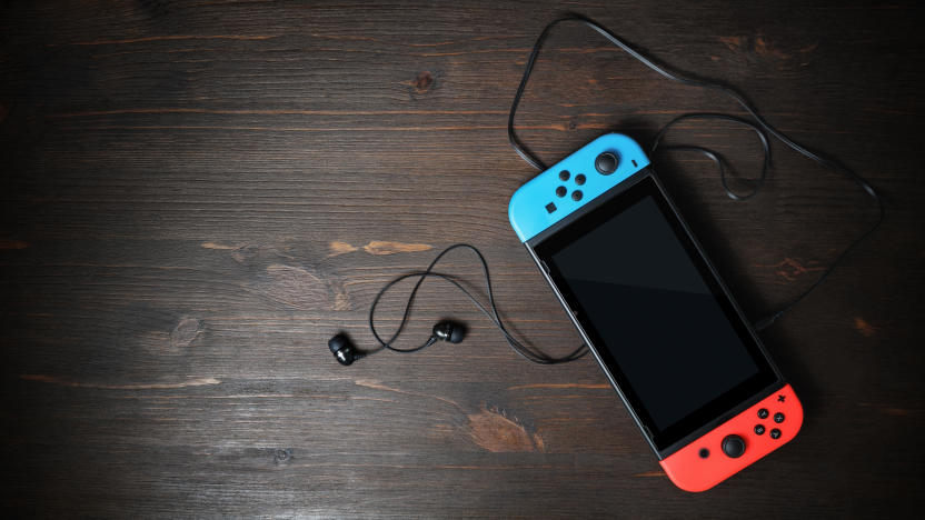Minsk, Belarus - May 07, 2020: Nintendo Switch game console with black screen and bright joy-con controllers on wood table background. Copy space for text. Top view. Flat lay.