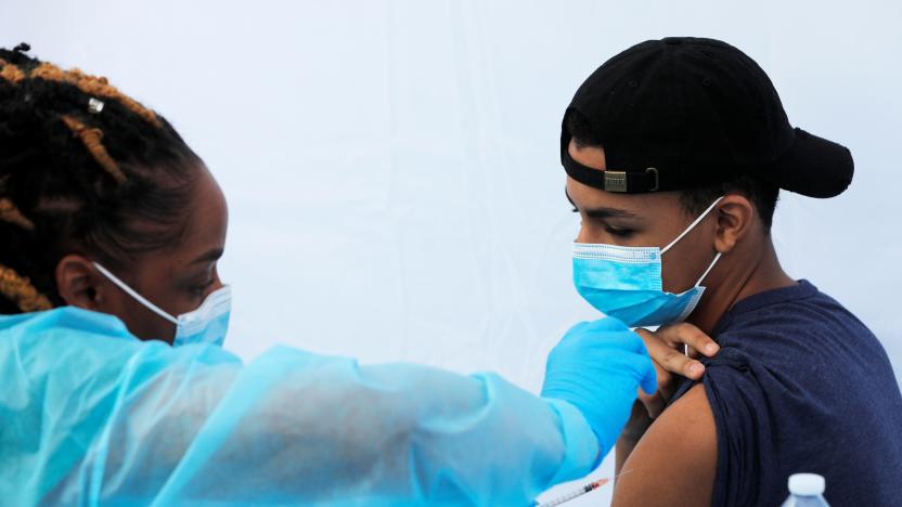 A teenage student receives a dose of the Pfizer-BioNTech vaccine for the coronavirus disease (COVID-19) during a vaccination event for local adolescents and adults outside the Bronx Writing Academy school in the Bronx borough of New York City, New York, U.S., June 4, 2021. REUTERS/Mike Segar