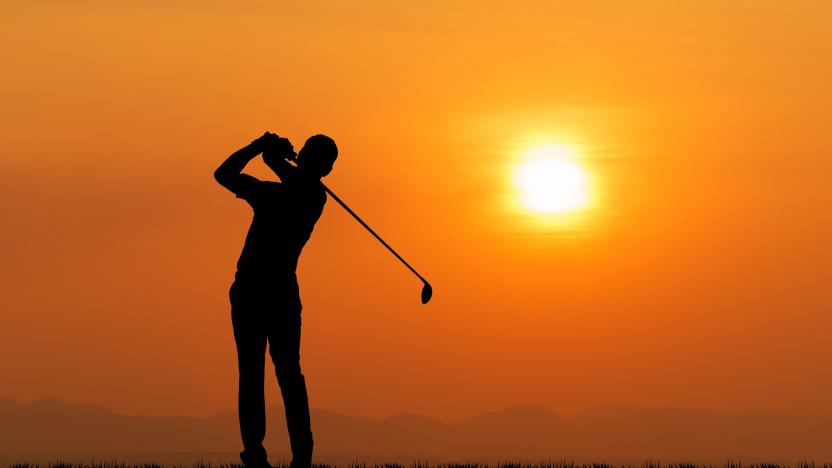 Silhouette of golfer against sunset