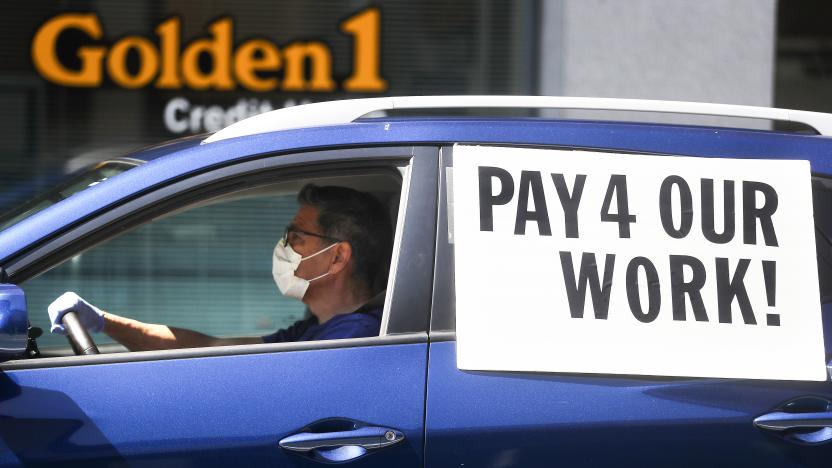 LOS ANGELES, CALIFORNIA - APRIL 16: A driver wears a face mask and gloves as Uber and Lyft drivers with Rideshare Drivers United and the  Transport Workers Union of America conduct a ‘caravan protest’ outside the California Labor Commissioner’s office amidst the coronavirus pandemic on April 16, 2020 in Los Angeles, California. The drivers called for California to enforce the AB 5 law so that they may qualify for unemployment insurance as the spread of COVID-19 continues. Drivers also called for receiving back wages they say they are owed. (Photo by Mario Tama/Getty Images)