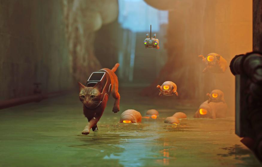 A still from the video game 'Stray' showing a cat in a sewer being followed by weird small alien turtle-like creatures.