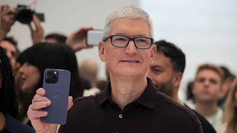 Apple CEO Tim Cook holds the new iPhone 14 at an Apple event at their headquarters in Cupertino, California, U.S. September 7, 2022. REUTERS/Carlos Barria