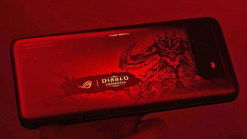 The ROG Phone 6 Diablo Immortal Edition seen resting on someone's hand in very dark red light.