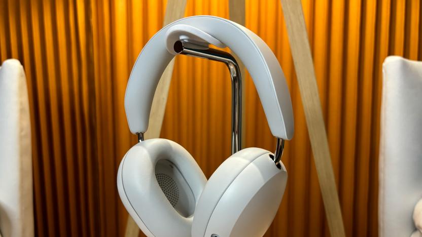 White headphones on stand sitting on a small table. 