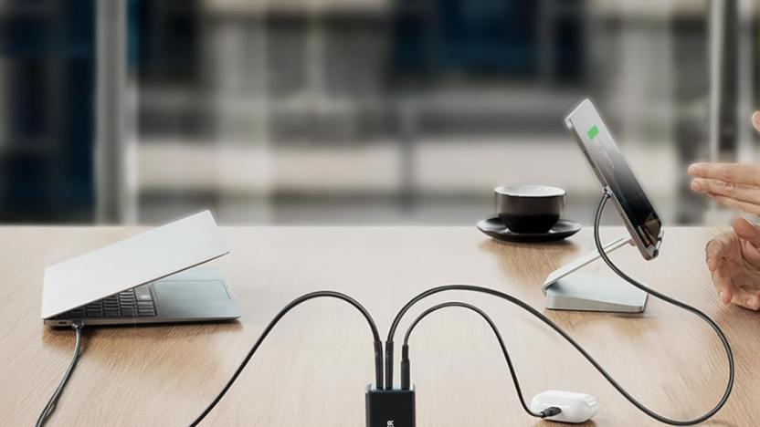 A charger on a table connected to multiple devices. 