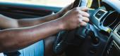 A man grips the steering wheel of his car. (Getty Images)