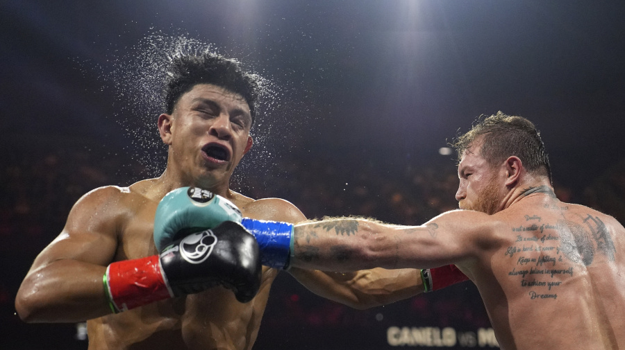 Associated Press - Canelo Alvarez hits Jaime Munguia in a super middleweight title fight Saturday, May 4, 2024, in Las Vegas. (AP Photo/John Locher)