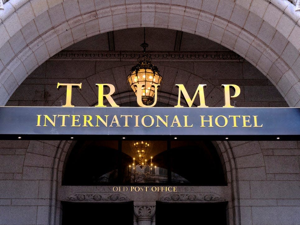 Workers began tearing down the gold letters of the Trump International Hotel's s..