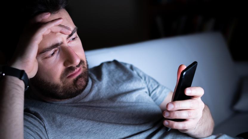 Sadness male portrait holding mobile phone alone