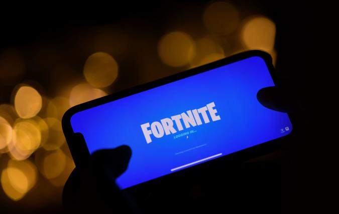 This illustration picture shows a person logging into Epic Games' Fortnite on their smartphone in Los Angeles on August 14, 2020. - Apple and Google on August 13, 2020 pulled video game sensation Fortnite from their mobile app shops after its maker Epic Games released an update that dodges revenue sharing with the tech giants. (Photo by Chris DELMAS / AFP) (Photo by CHRIS DELMAS/AFP via Getty Images)
