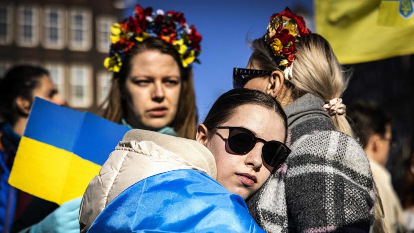 A girl wrapped in a Ukrainian national flag looks on during the anti-war demonstration on Dam Square organised by Peace organization PAX to show their support for Ukrainian refugees and to condemn the Russian invasion, in Amsterdam, on March 6, 2022. - Netherlands OUT (Photo by Ramon van Flymen / ANP / AFP) / Netherlands OUT (Photo by RAMON VAN FLYMEN/ANP/AFP via Getty Images)