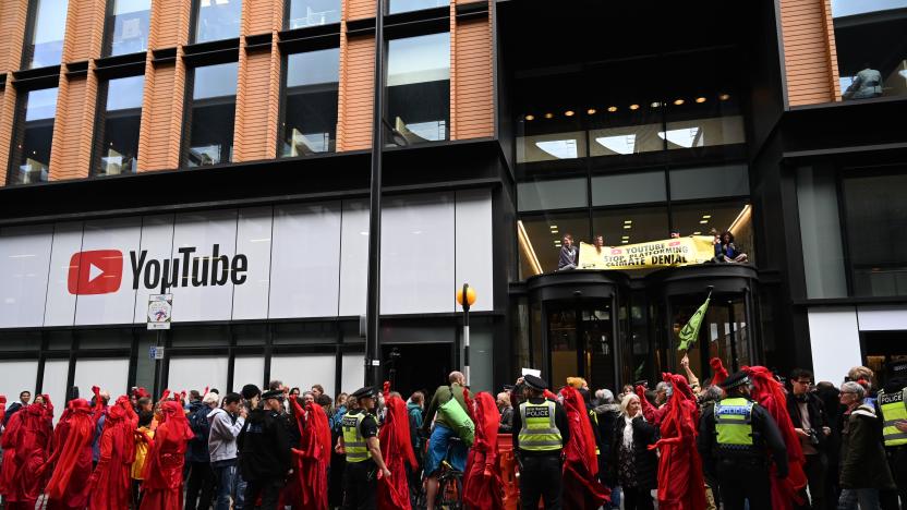 Climate activists hold a banner after climbing atop the roof of the entrance of the building and others line the pavement at ground level as they protest outside the UK office of Youtube during the tenth day of demonstrations by the climate change action group Extinction Rebellion, in London, on October 16, 2019. - Activists from the environmental campaign group Extinction Rebellion vowed Wednesday to challenge a blanket protest ban imposed by the London police. (Photo by Paul ELLIS / AFP) (Photo by PAUL ELLIS/AFP via Getty Images)