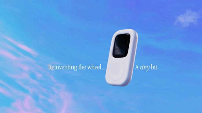 Marketing image for the tinyPod. The product, which looks like an iPod with click wheel, floats in front of a blue sky. Text: "Reinventing the wheel ... A tiny bit." Oughts-era Apple font and marketing style.