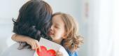 Parent holding young girl. (Getty Images) 