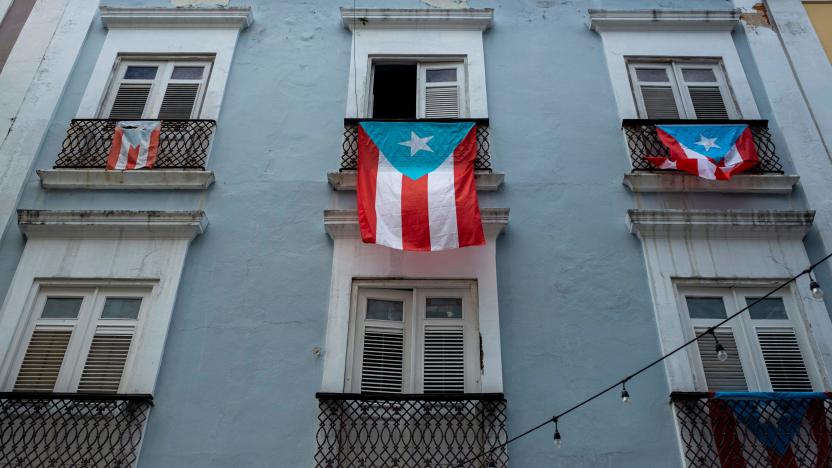 Puerto Rican National flags hang from balconies in Old San Juan, Puerto Rico on April 7, 2020. - On March 15, 2020, Puerto Rico Governor Wanda Vazquez Garced imposed a curfew shuttering non-essential businesses on the island and ordered people to stay home from 7 p.m. to 5 a.m. In addition, from March 31, she imposed even tighter measures, including requiring anyone entering a business to wear a face mask. (Photo by Ricardo ARDUENGO / AFP) (Photo by RICARDO ARDUENGO/AFP via Getty Images)