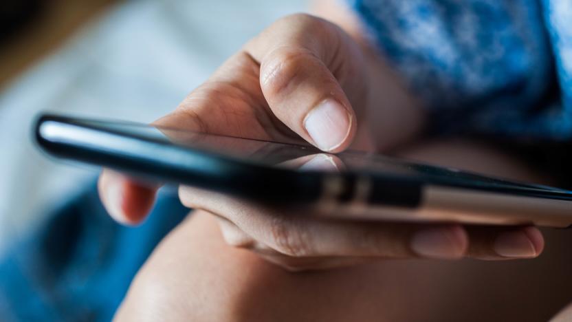 A close up of the hands of a young woman using a mobile phone