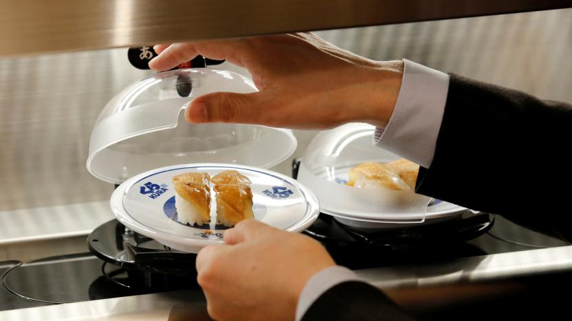 A man picks up a sushi from conveyor belt during a media event a day before the official opening of Kura Sushi's new branch in Tokyo, Japan, January 21, 2020. REUTERS/Kim Kyung-Hoon