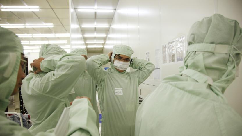 Employees put on clean suits before entering the wafer FAB of Semiconductor Manufacturing International Corp in Shanghai, China on 18 February, 2011.   The Taiwan based manufacturer is one of the largest chip foundries in the world. (Photo by In Pictures Ltd./Corbis via Getty Images)