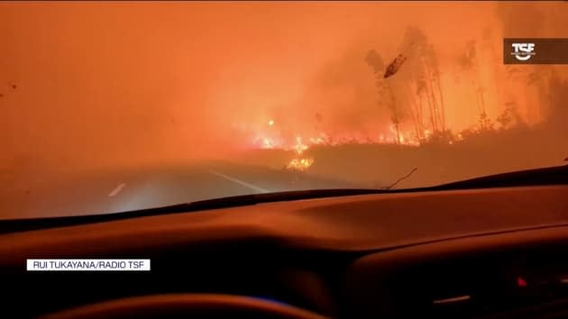 Journalist filming crossing a fire in the middle of the highway