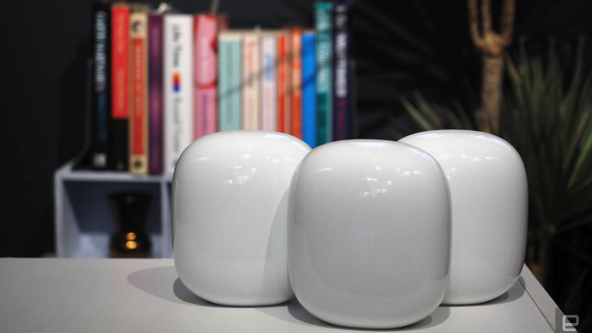 Image of three Nest WiFi Pro units on a table in front of a blurred bookshelf.