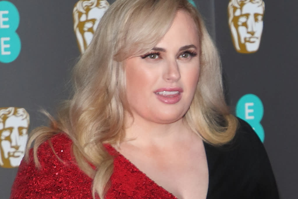 Rebel Wilson makes her button-up jeans look luxurious with shiny leggings and trendy platform sneakers